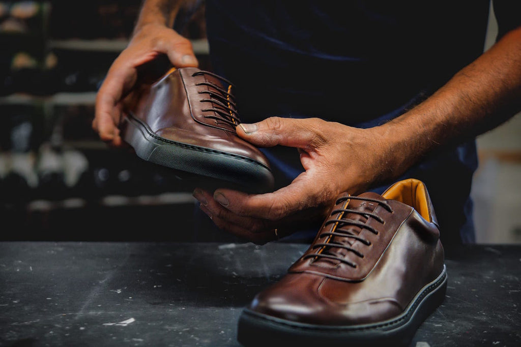 Artisan showing finished shoes