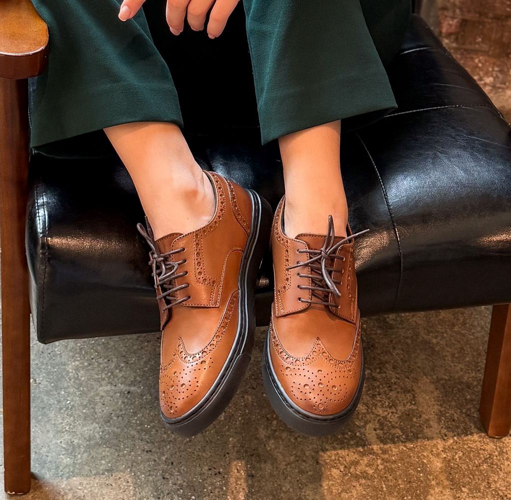 Woman wearing brown cognac leather wingtip dress sneakers made in italy