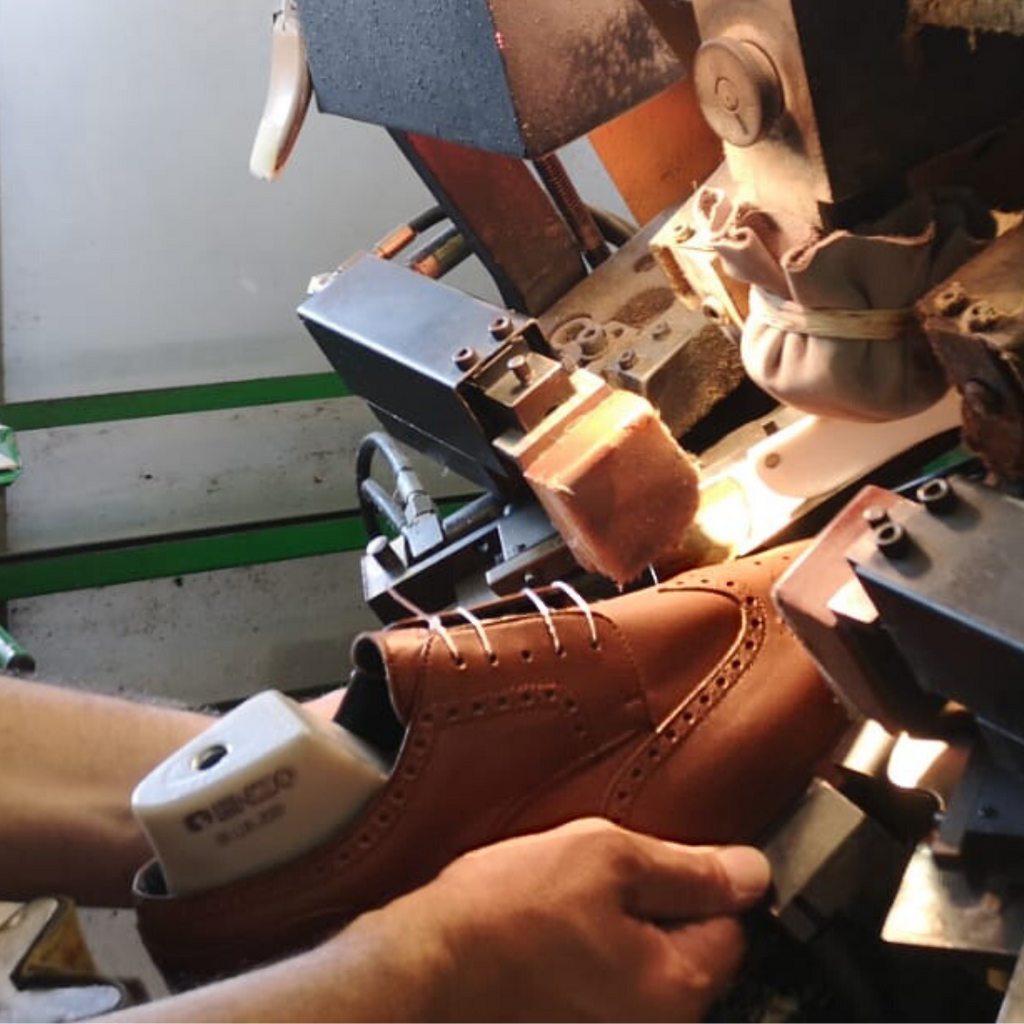 Brown cognac leather wingtip dress sneakers being made by artisan in Italy