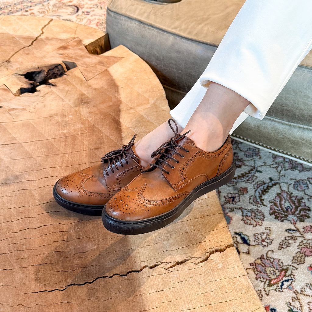 Woman wearing cognac brogue wingtip italian leather dress sneakers