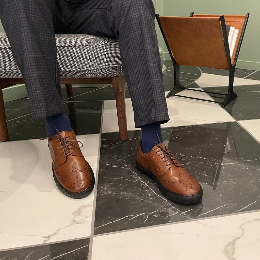 Man Sitting in Office Wearing Brown Sneakers