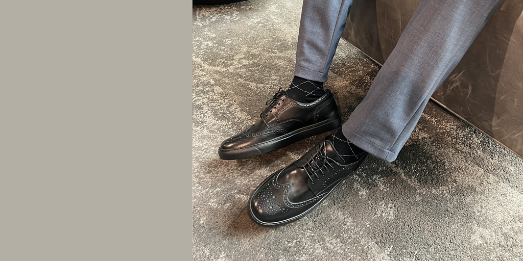 Man wearing black leather wingtip brogue dress sneakers made in italy