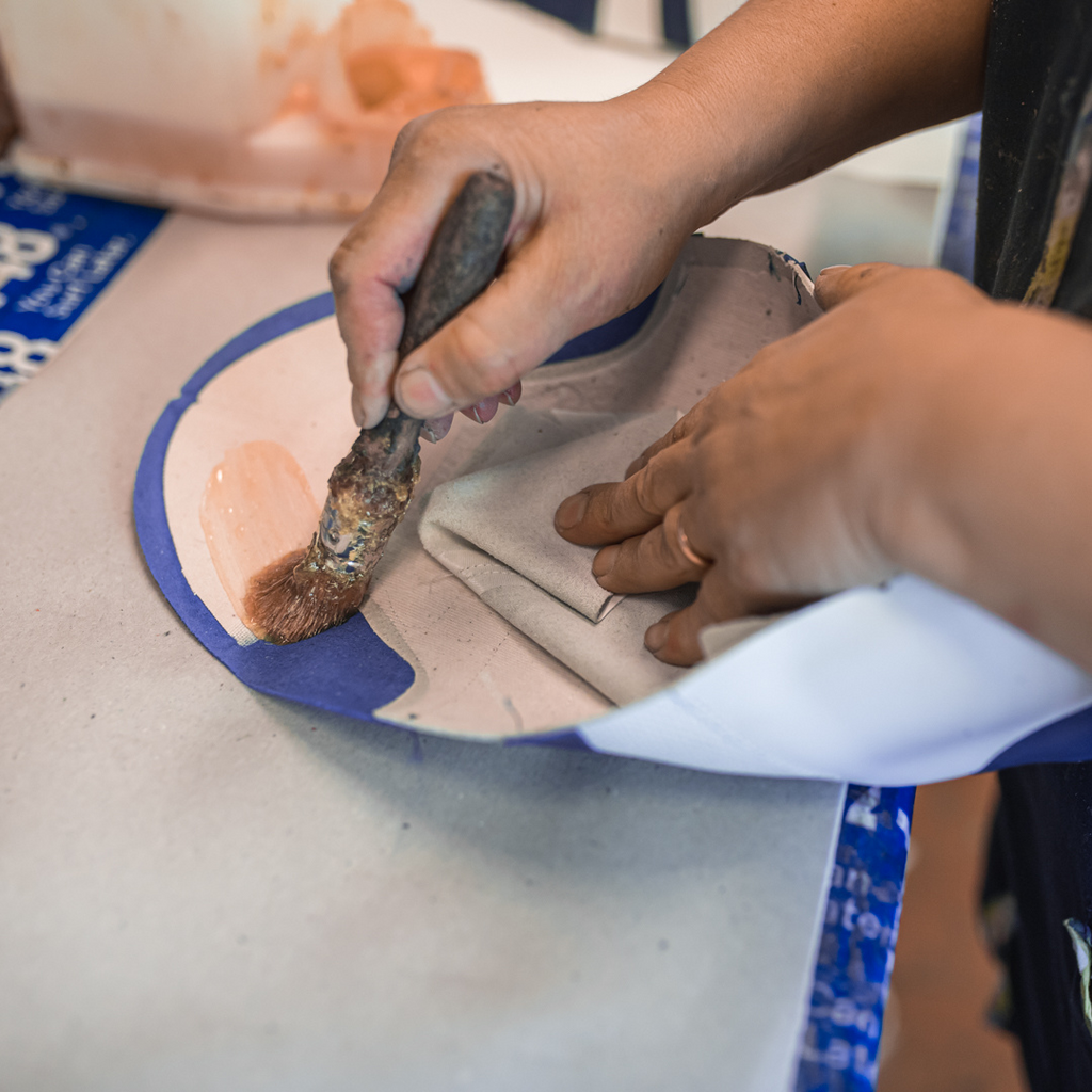 Artisan in Italy making mens leather sneaker in white.