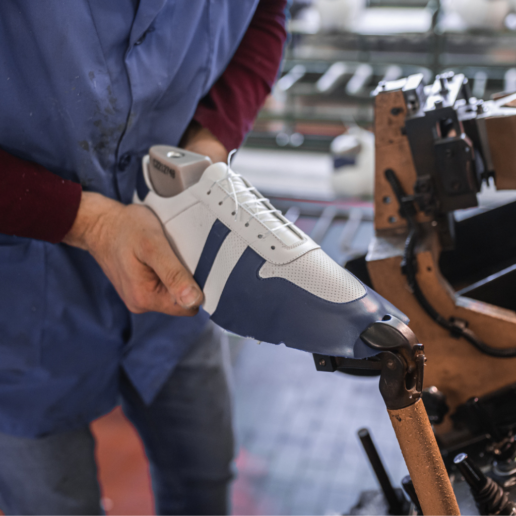 Artisan in Italy making mens leather sneaker in white.