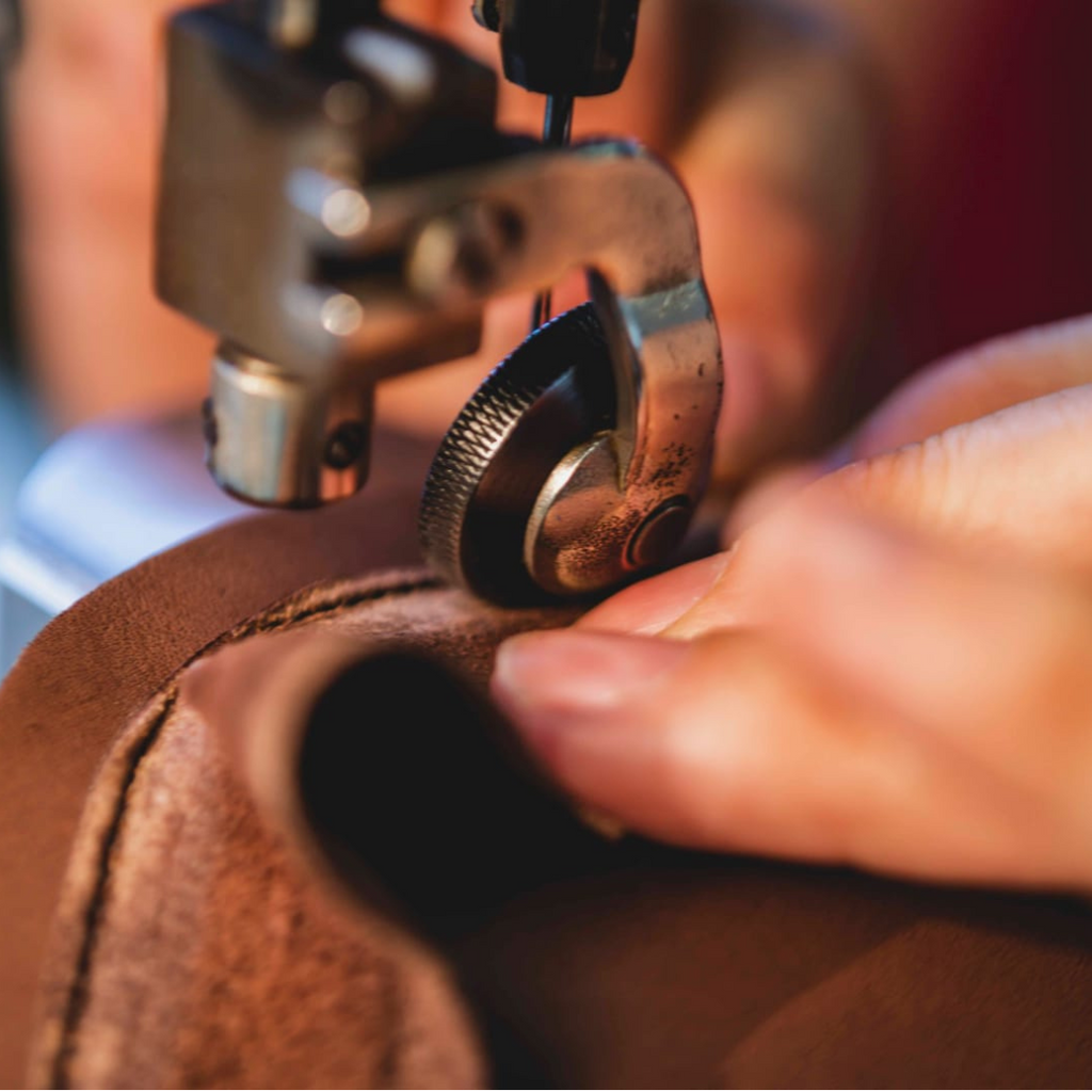 Artisan in Italy sewing brown leather dress sneakers