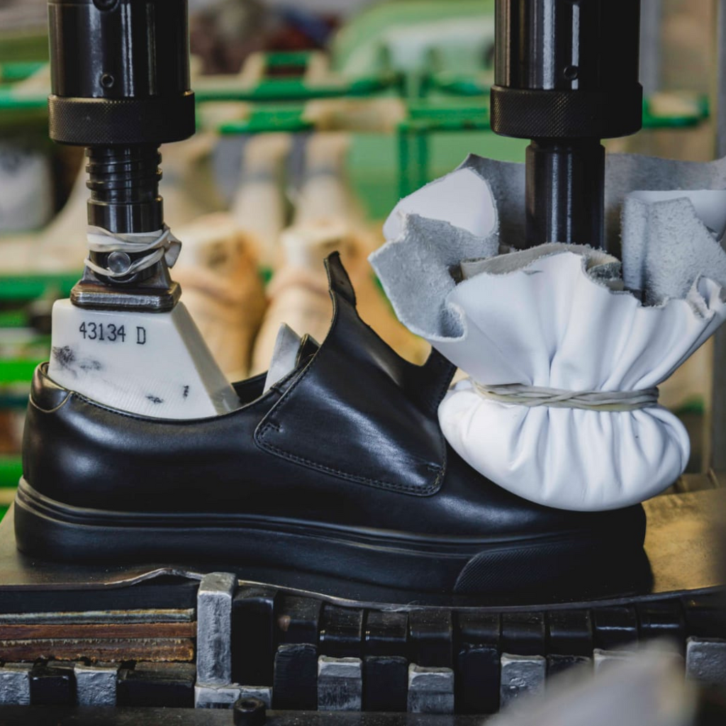 Women's black leather monk strap dress sneakers being buffed in Italy factory