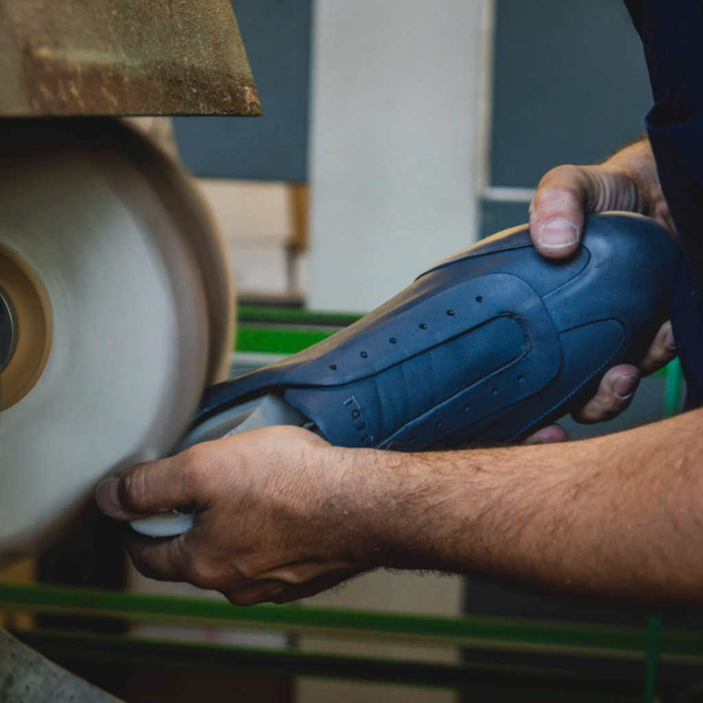 Artisan in Italy hand buffing blue leather dress sneakers