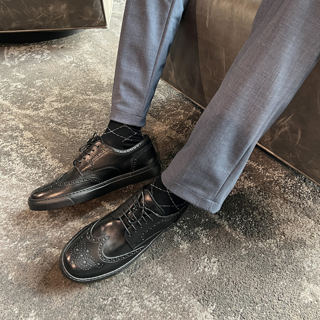 Man wearing black leather wingtip brogue dress sneakers made in italy