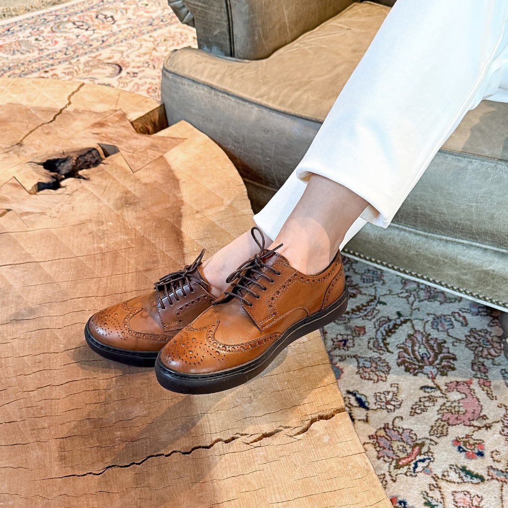 Woman wearing cognac leather wingtip brogue dress sneakers made in Italy
