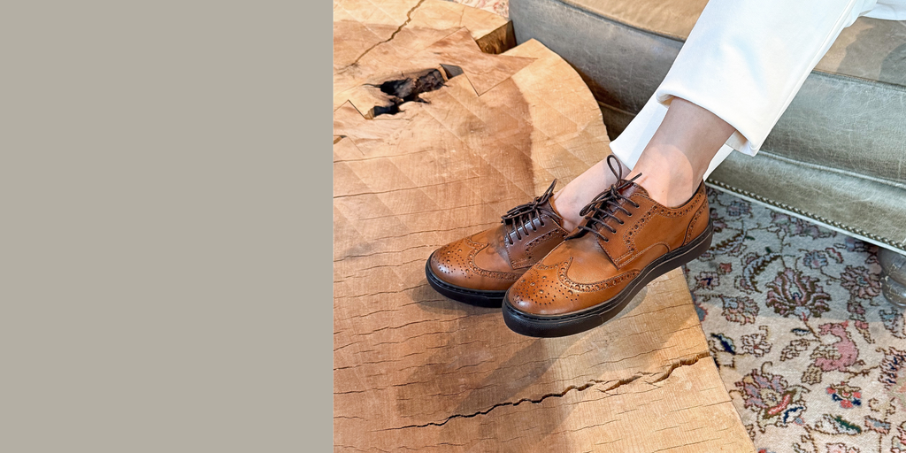 Woman wearing cognac leather wingtip brogue dress sneakers made in Italy